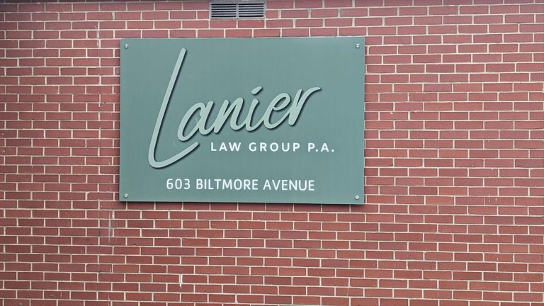 Law firm sign on brick wall at Lanier Law Group P.A., 603 Biltmore Avenue.