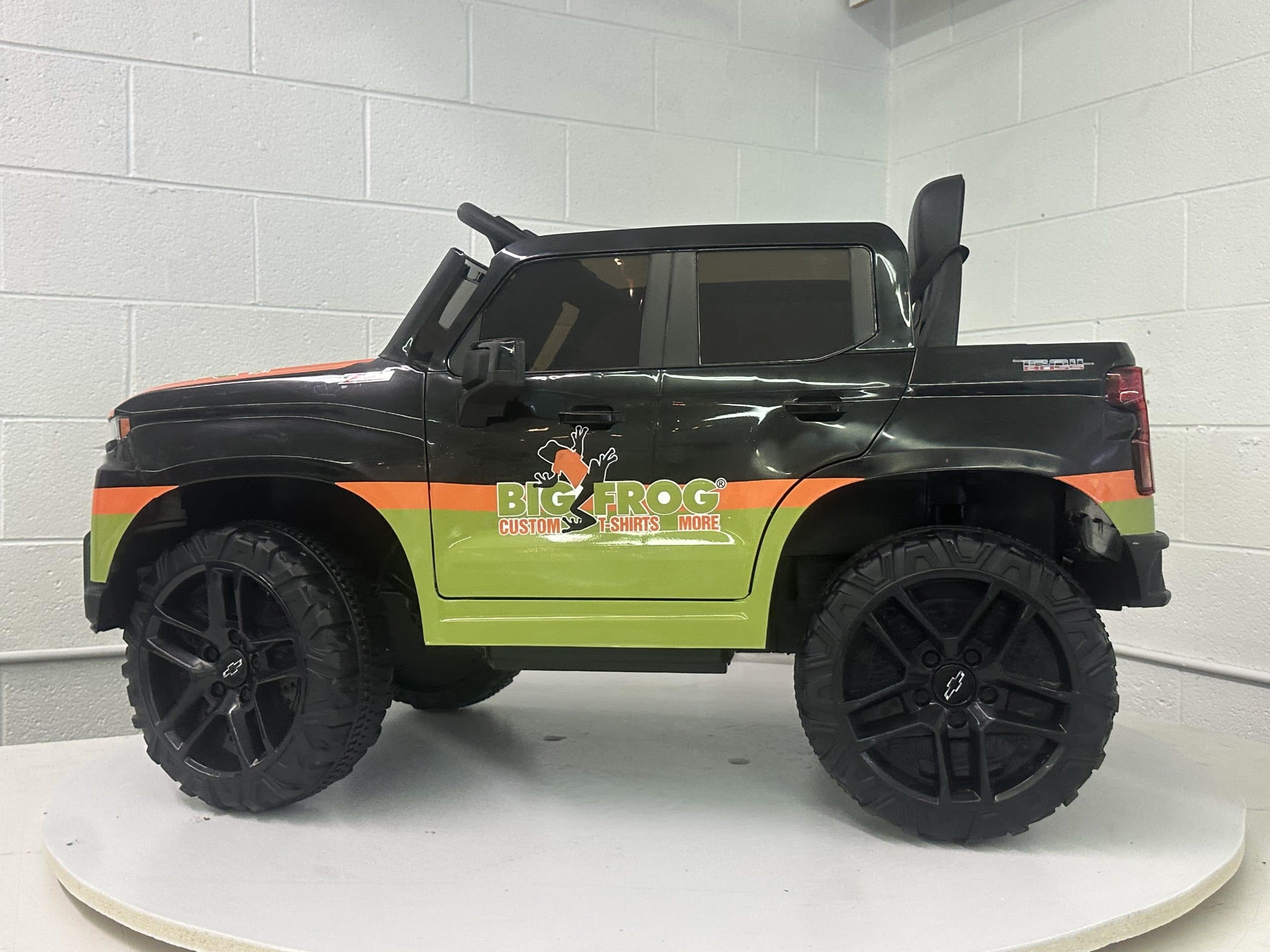 Miniature car with Big Frog custom branding and vibrant green and orange design, ideal for promotional displays.